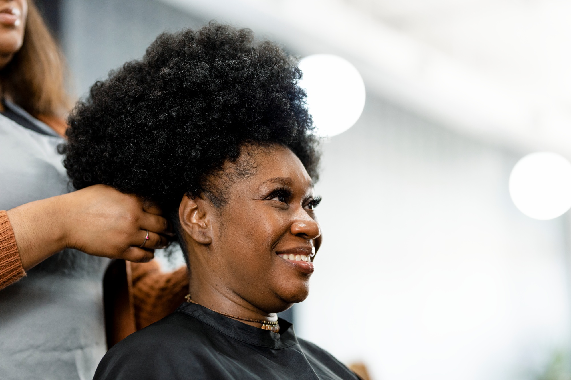 Hairstylist giving a finish touch for the customer's hairdo